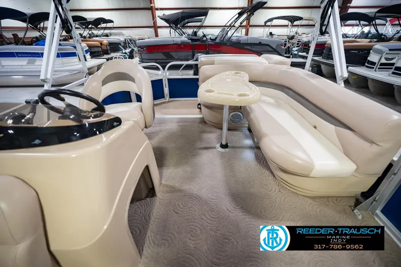 Slide: The Image of 2014 Sun Tracker Party Barge 20 DLX interior with seating and steering console in showroom. - 17