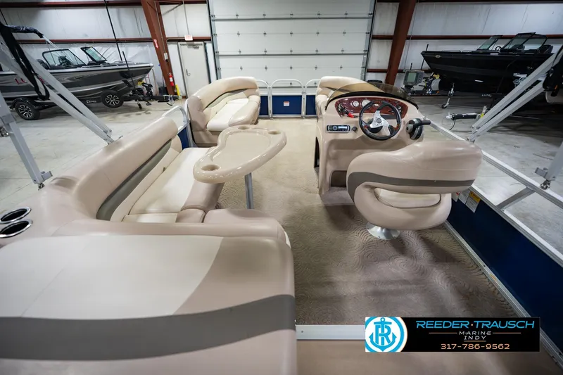 Slide: The Image of 2014 Sun Tracker Party Barge 20 DLX interior with beige seating and steering console. - 19