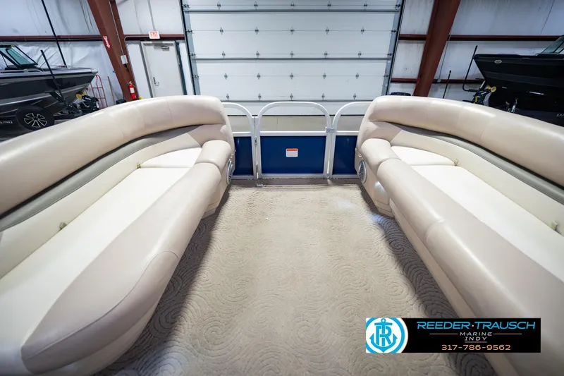 Slide: The Image of 2014 Sun Tracker Party Barge 20 DLX interior with beige seating in a showroom. - 21