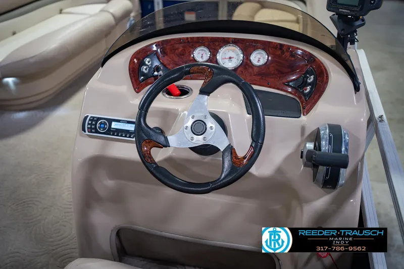 Slide: The Image of 2014 Sun Tracker Party Barge 20 DLX steering console with wood accents and gauges. - 27