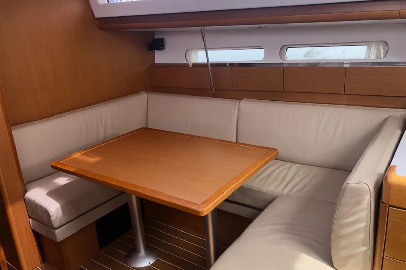 Slide: The Image of Interior of 2017 Jeanneau Sun Odyssey 41 DS, featuring a cozy dining area with wooden table. - 6