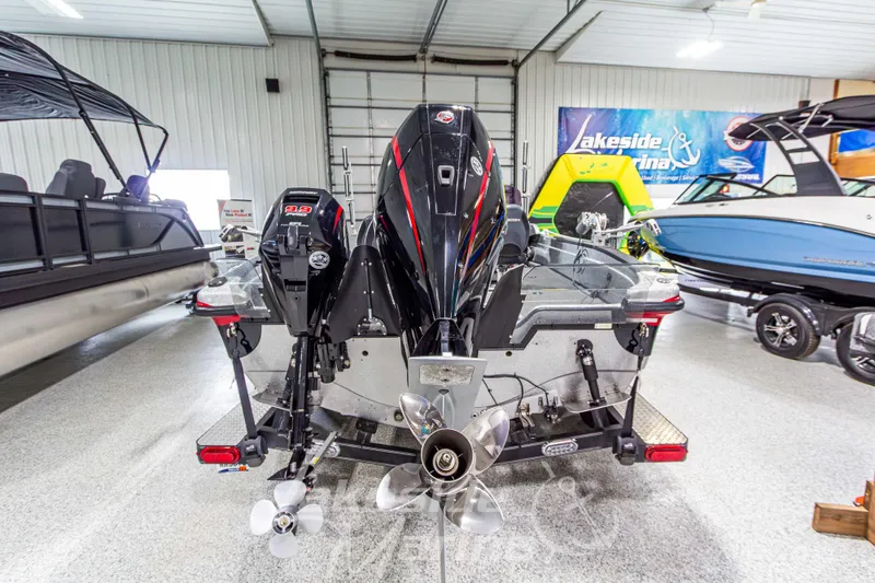 Slide: The Image of 2019 Recon 2185 SC boat with dual outboard motors in a showroom. - 4