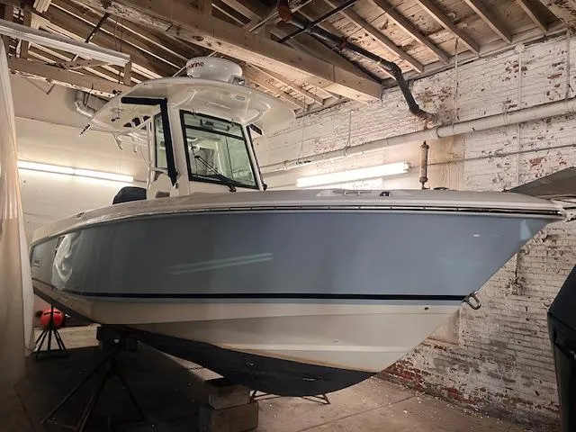 Slide: The Image of 2022 Boston Whaler 250 Outrage boat in a rustic indoor setting. - 2
