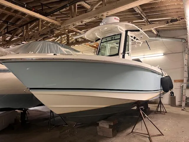 Slide: The Image of 2022 Boston Whaler 250 Outrage boat in storage, light blue hull, indoor setting. - 3