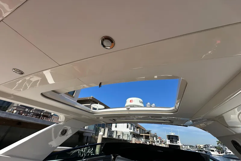 Slide: The Image of Interior view of 2018 Sea Ray SLX 400 yacht with open sunroof and waterfront backdrop. - 13