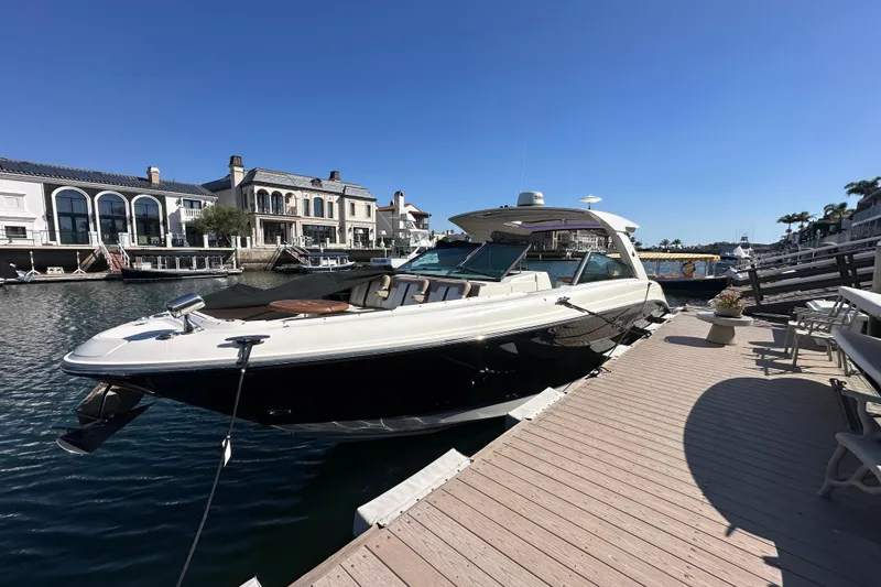 Slide: The Image of 2018 Sea Ray SLX 400 docked at a marina, surrounded by waterfront buildings. - 23