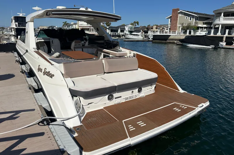 Slide: The Image of 2018 Sea Ray SLX 400 yacht docked in a marina, featuring spacious deck and seating. - 4