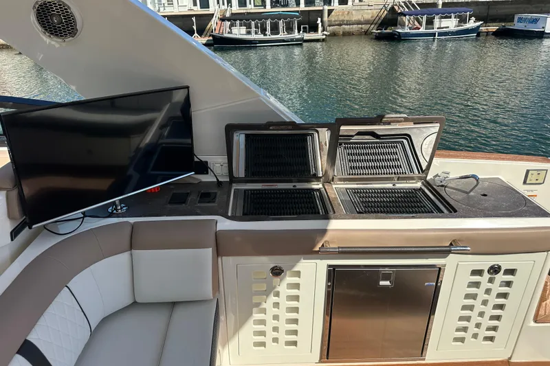 Slide: The Image of Luxury 2018 Sea Ray SLX 400 yacht with outdoor grill and TV setup by the water. - 8