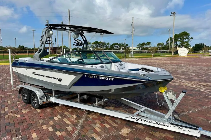The Image of 2018 Nautique Super Air Nautique GS22 boat on trailer, parked on brick pavement. - 1