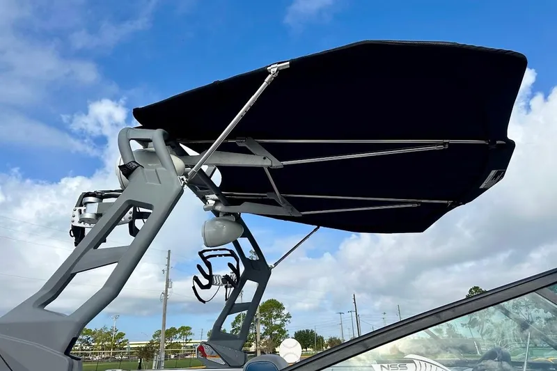 Slide: The Image of 2018 Nautique Super Air Nautique GS22 boat with bimini top against blue sky. - 11