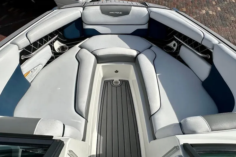 Slide: The Image of 2018 Nautique Super Air Nautique GS22 boat interior with cushioned seating and storage compartments. - 39