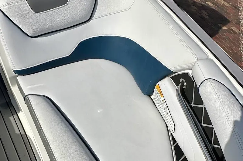 Slide: The Image of 2018 Nautique Super Air Nautique GS22 boat interior seating, featuring white and blue upholstery. - 40