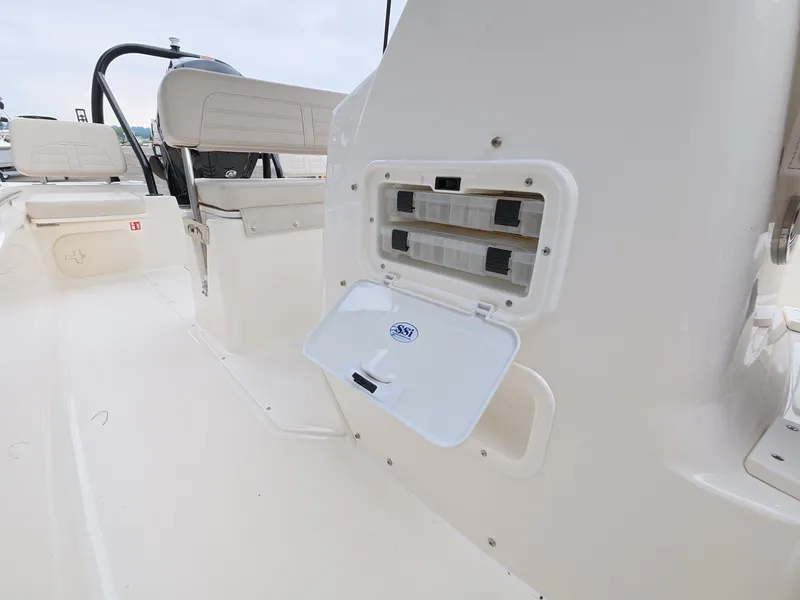 Slide: The Image of The image shows the cockpit of a 2027 Boston Whaler 170 Montauk with storage space. - 18
