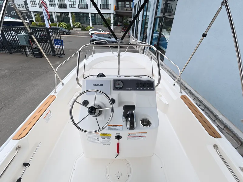 Slide: The Image of The image shows the cockpit of a 2027 Boston Whaler 170 Montauk with a helm and steering wheel. - 13