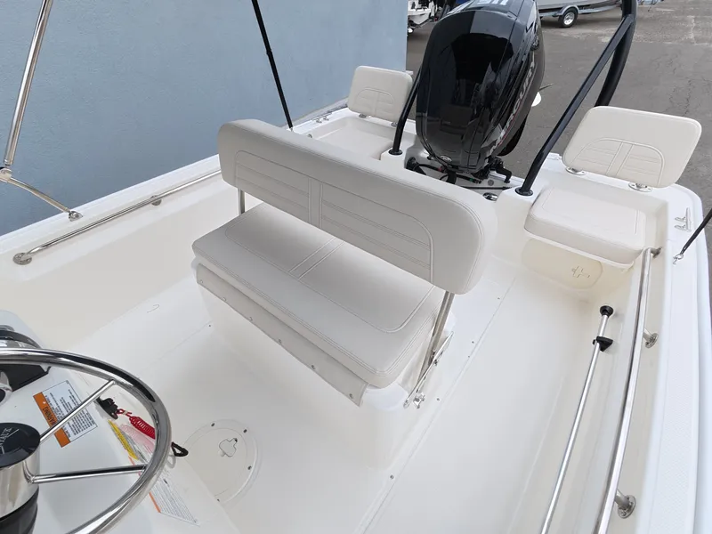 Slide: The Image of The image shows the cockpit of a Boston Whaler 170 Montauk with white upholstery and an outboard motor. - 12