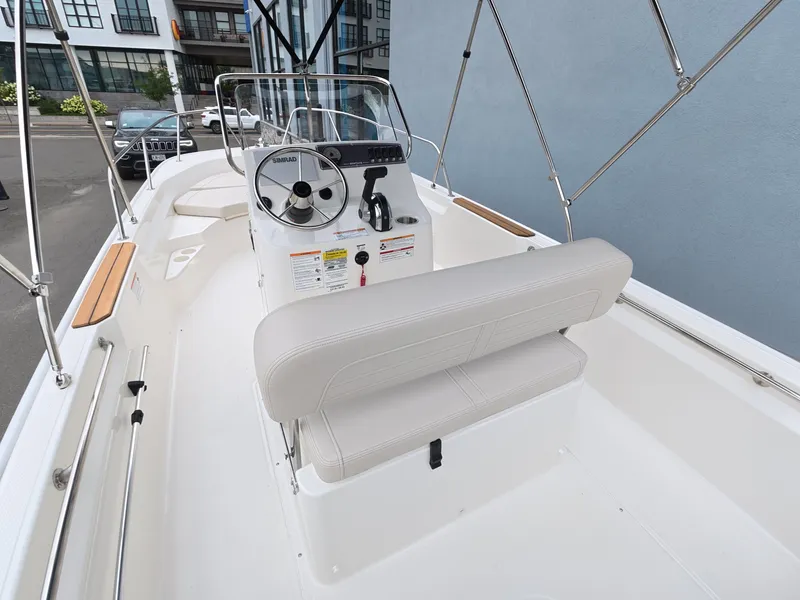 Slide: The Image of The image shows the cockpit of a Boston Whaler 170 Montauk with a white helm and bench seat. - 11