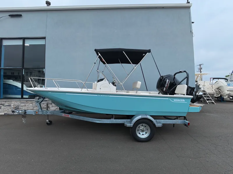 Slide: The Image of A 2027 Boston Whaler 170 Montauk on a trailer outside a building. - 1