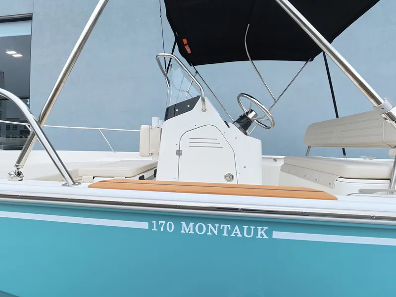 Slide: The Image of A 2027 Boston Whaler 170 Montauk with a turquoise hull and black sunshade. - 5
