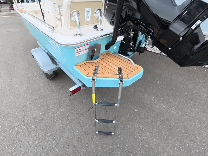 Slide: The Image of The 2027 Boston Whaler 170 Montauk features a swim platform with a ladder and outboard motor. - 8