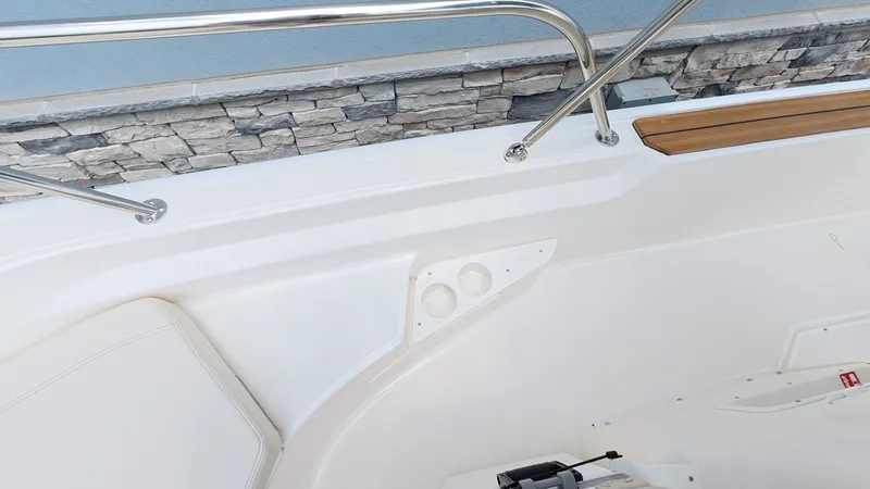 Slide: The Image of Close-up of a Boston Whaler 170 Montauk interior with stainless steel railing and stone wall backdrop. - 22