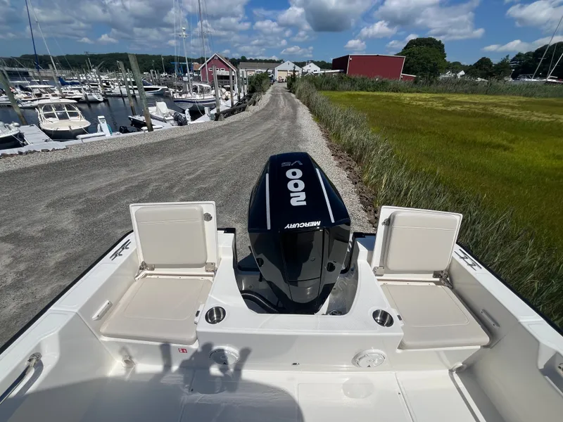 Slide: The Image of View from the stern of a Boston Whaler 210 Montauk with a Mercury engine, surrounded by a marina. - 2