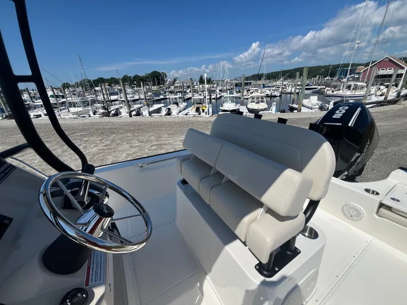 Slide: The Image of The image shows the cockpit of a 2027 Boston Whaler 210 Montauk at a marina. - 6