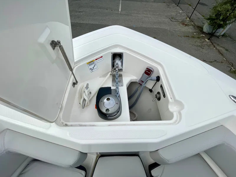 Slide: The Image of The bow of the Boston Whaler 330 Outrage features an open storage compartment with a windlass and rope. - 22