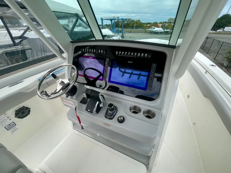 Slide: The Image of The 2027 Boston Whaler 330 Outrage cockpit features a modern helm with dual screens. - 17