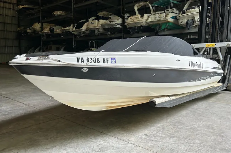 Slide: The Image of 2005 Maxum 2200 SR3 boat in storage, covered and elevated, with visible registration number. - 3