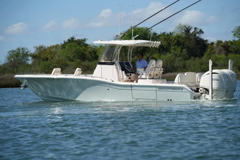 Slide: The Image of 2025 Grady-White 281 Coastal Explorer boat cruising on a serene waterway. - 10