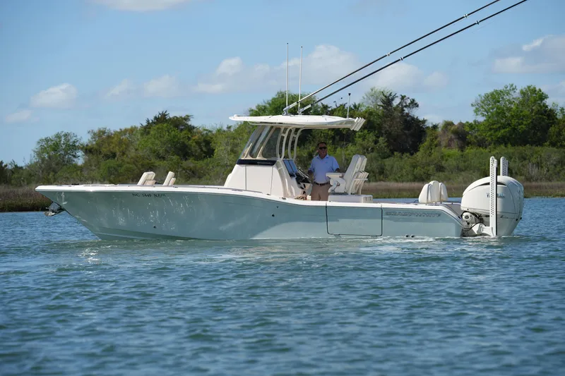 Slide: The Image of 2025 Grady-White 281 Coastal Explorer boat cruising on a serene waterway. - 11
