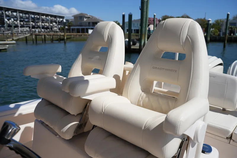 Slide: The Image of Luxury seating on 2025 Grady-White 281 Coastal Explorer boat, docked by marina. - 26