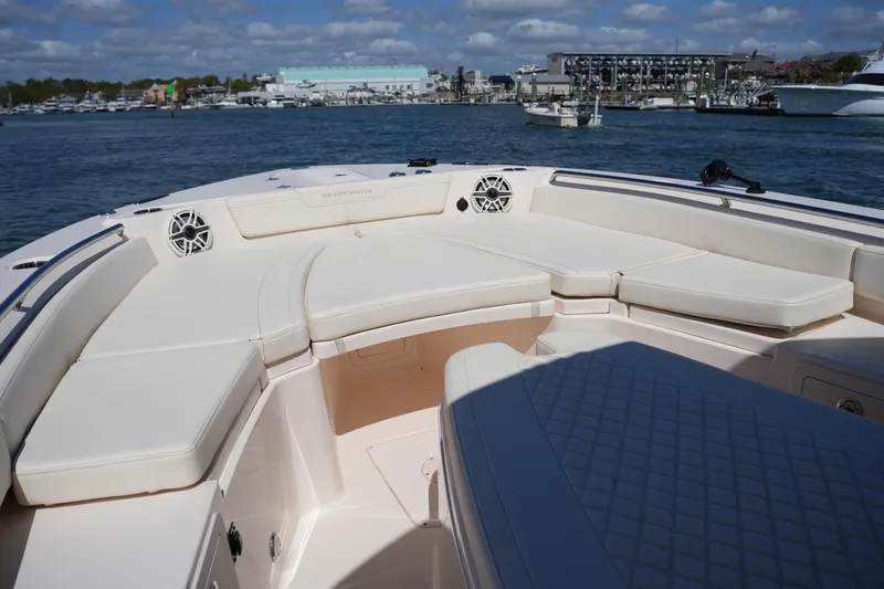 Slide: The Image of 2025 Grady-White 281 Coastal Explorer boat interior with cushioned seating, docked in marina. - 40