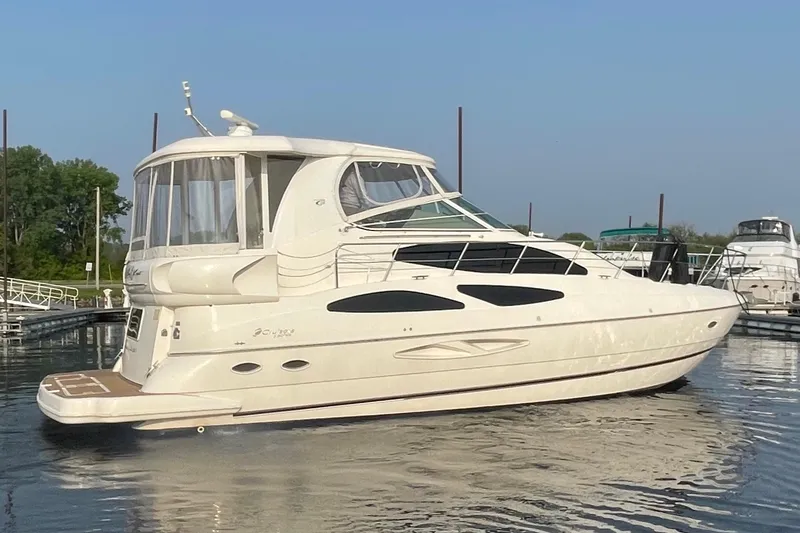 The Image of 2004 Cruisers Yachts 455 Express Motoryacht docked on calm water. - 0