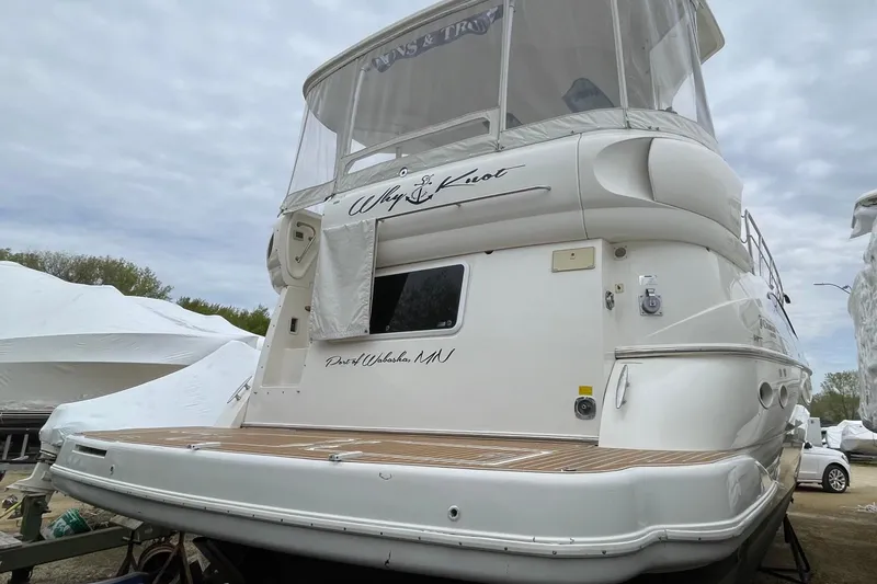 Slide: The Image of 2004 Cruisers Yachts 455 Express Motoryacht docked, featuring sleek design and spacious deck. - 22