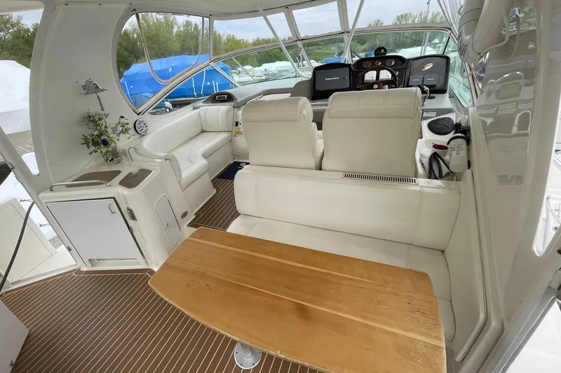 Slide: The Image of Interior of 2004 Cruisers Yachts 455 Express Motoryacht with white seating and wooden table. - 25