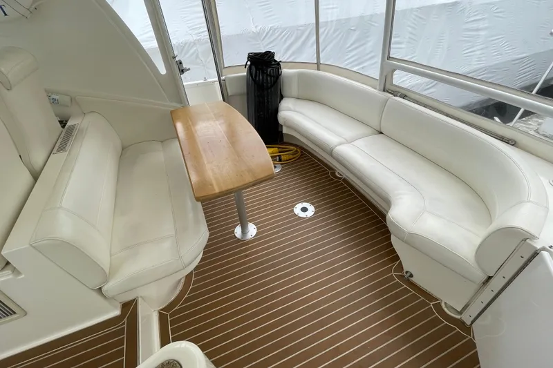 Slide: The Image of Luxurious seating area on 2004 Cruisers Yachts 455 Express Motoryacht with wooden table. - 27