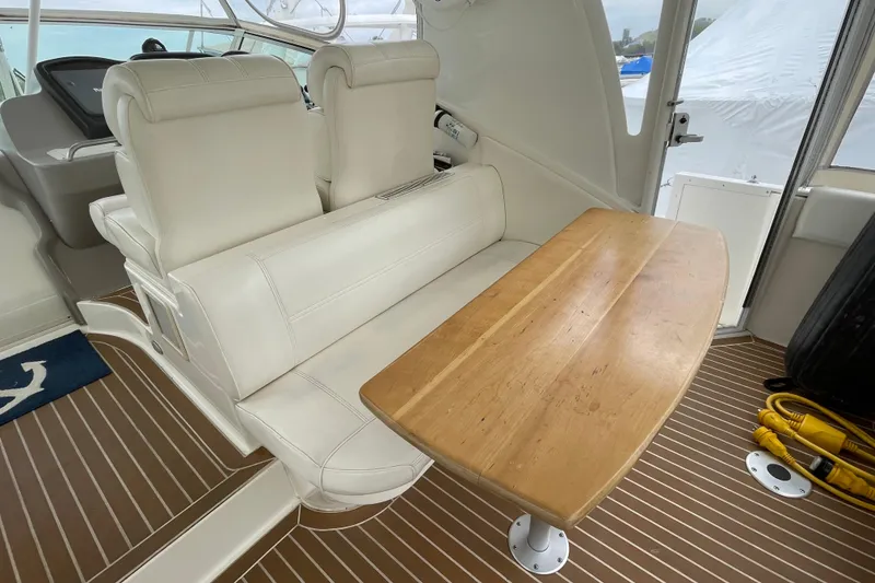 Slide: The Image of 2004 Cruisers Yachts 455 Express Motoryacht interior with white seating and wooden table. - 28