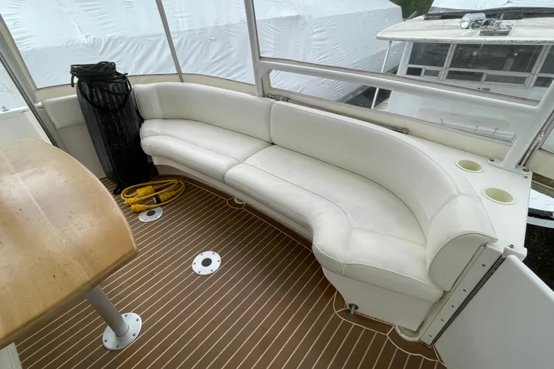 Slide: The Image of 2004 Cruisers Yachts 455 Express Motoryacht interior with white seating and wooden table. - 29