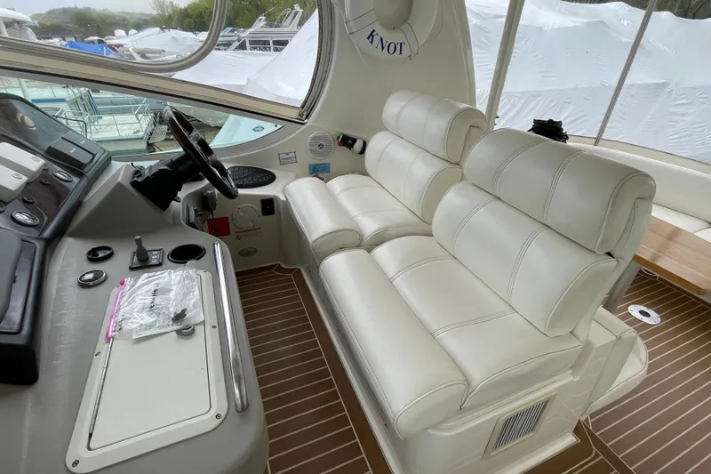 Slide: The Image of 2004 Cruisers Yachts 455 Express Motoryacht helm with white leather seating and control panel. - 30