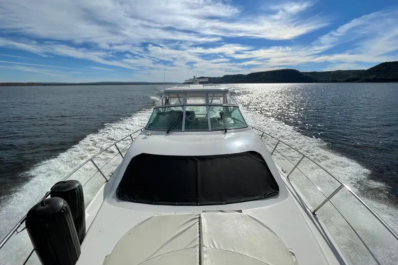 Slide: The Image of 2004 Cruisers Yachts 455 Express Motoryacht cruising on a sunny day, scenic water view. - 8