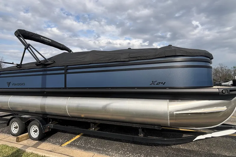 The Image of 2026 Viaggio X24U pontoon boat on trailer under cloudy sky. - 1