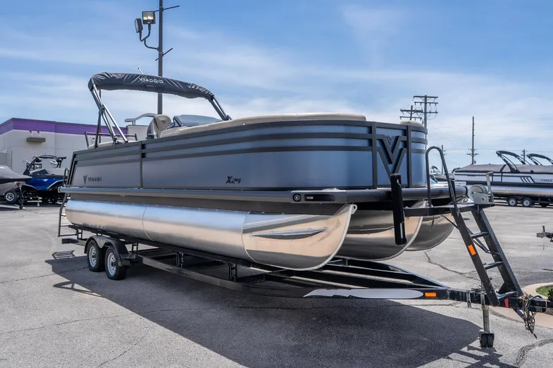 Slide: The Image of 2026 Viaggio X24U pontoon boat on trailer in parking lot, under clear blue sky. - 18