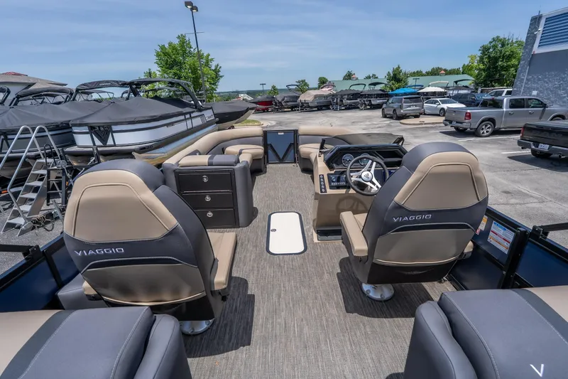 Slide: The Image of 2026 Viaggio X24U pontoon boat interior with luxurious seating and modern dashboard in a marina. - 8