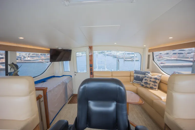 Slide: The Image of Luxurious interior of 2003 Viking 65 EB yacht with leather seating and marina view. - 18
