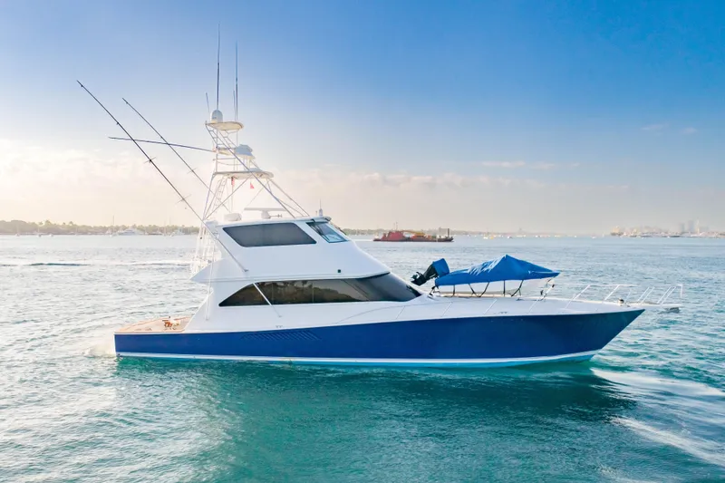 Slide: The Image of 2003 Viking 65 EB yacht cruising on calm blue waters under a clear sky. - 2