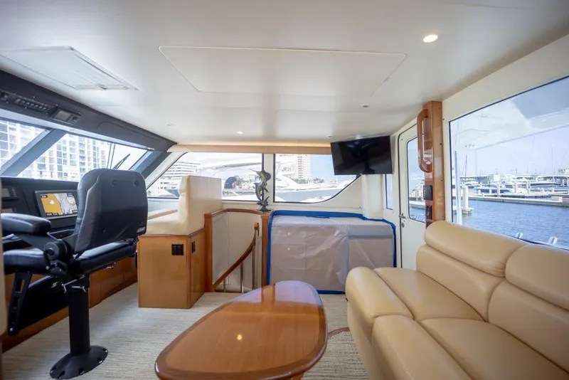 Slide: The Image of Luxurious interior of 2003 Viking 65 EB yacht with helm, seating, and marina view. - 20