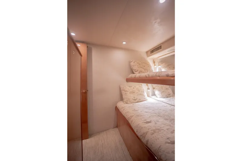 Slide: The Image of Interior of 2003 Viking 65 EB yacht with cozy bunk beds and soft lighting. - 26