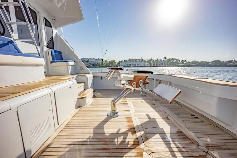 Slide: The Image of Luxurious 2003 Viking 65 EB yacht deck with fishing chair, overlooking serene waters. - 29