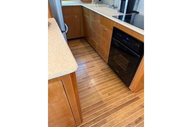 Slide: The Image of Kitchen interior of 2003 Viking 65 EB yacht with wooden flooring and modern appliances. - 30